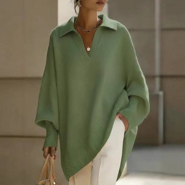 Person wearing a green poncho with a neutral background