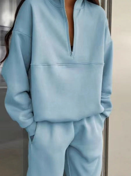 Light blue tracksuit worn by a person, with a neutral background
