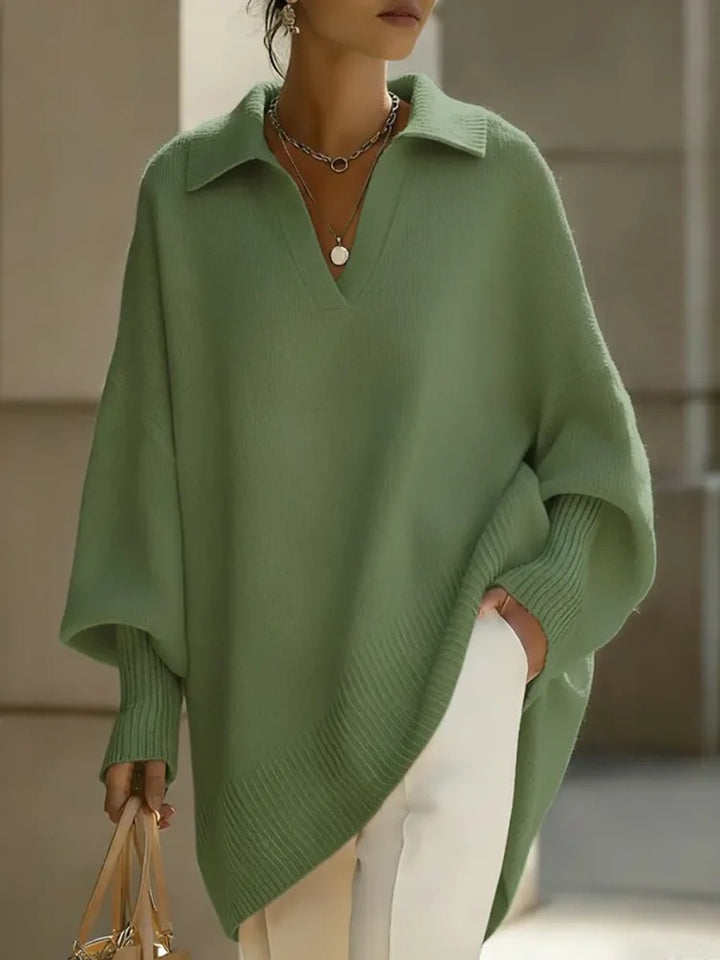 Person wearing a green poncho with a neutral background