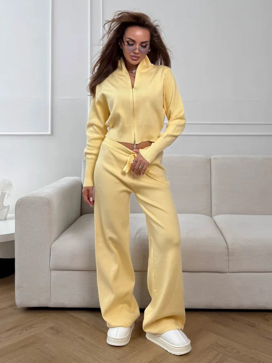 Woman in a yellow tracksuit standing in a modern living room.