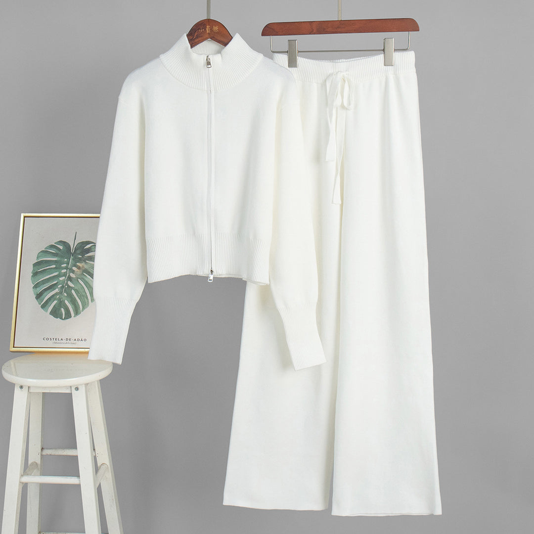 White outfit with a shirt and pants on hangers against a gray background