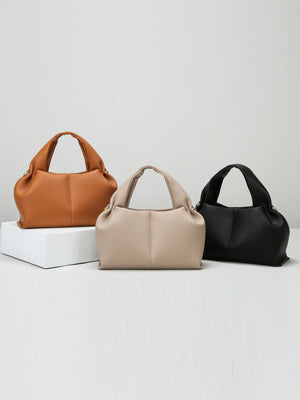 Three handbags in brown, beige, and black on a light gray background