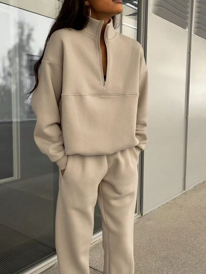 Person wearing a beige tracksuit standing indoors.