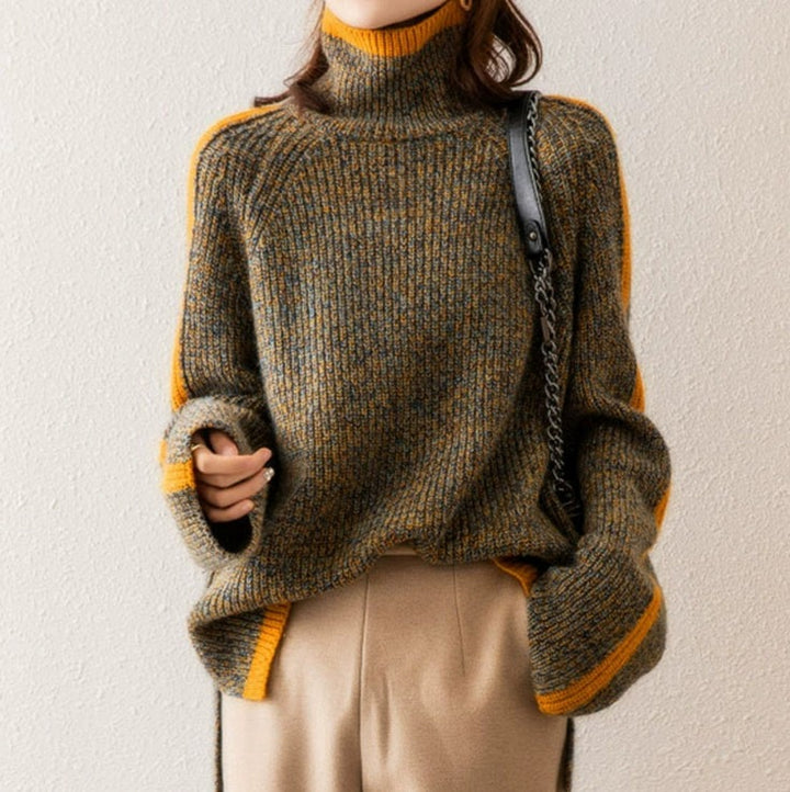Person wearing a brown and yellow sweater with beige pants against a plain background