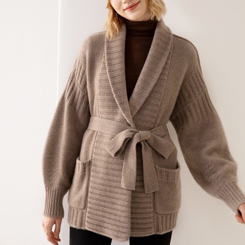 Brown knit cardigan worn by a person on a plain background