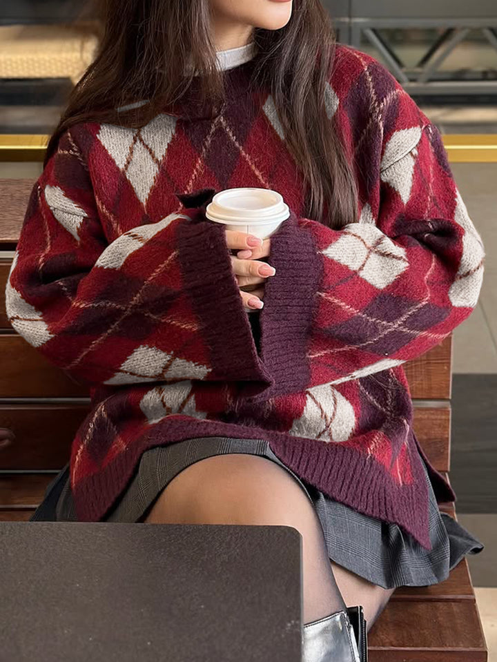 Person wearing a patterned sweater holding a coffee cup on a bench.