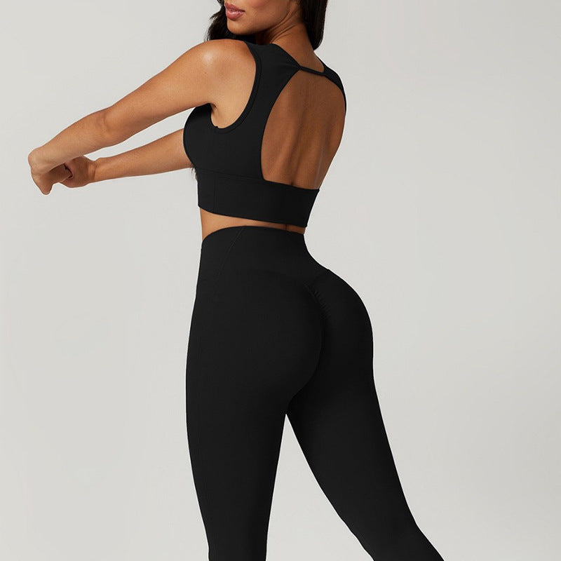 Person wearing a black sports bra and leggings on a light gray background