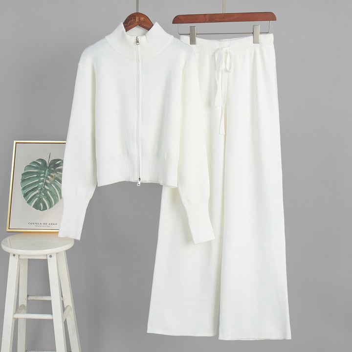 White outfit with a shirt and pants on hangers against a gray background