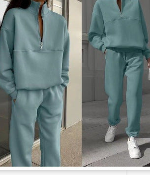 Teal tracksuit worn by a person indoors with a neutral background