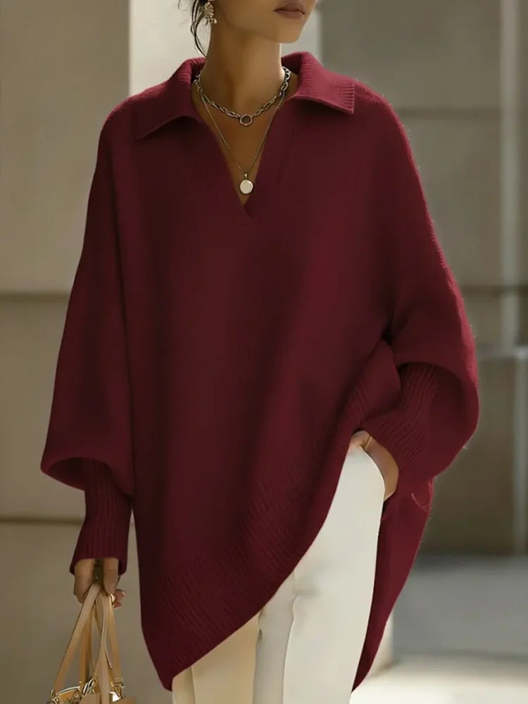 Person wearing a burgundy poncho with a neutral background