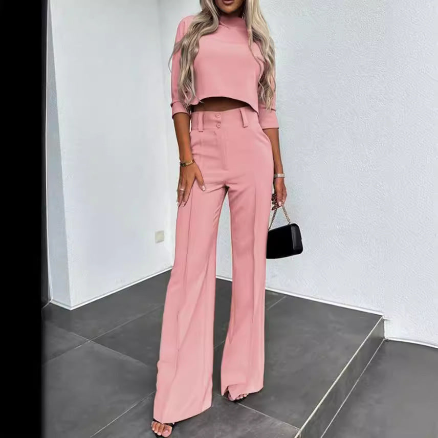Woman wearing a pink outfit with wide-leg pants in a minimalistic setting