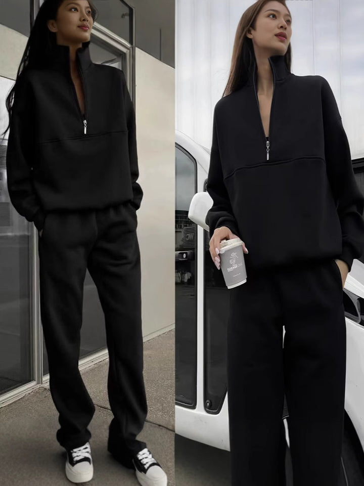 Woman in black outfit holding a coffee cup, standing next to a car.