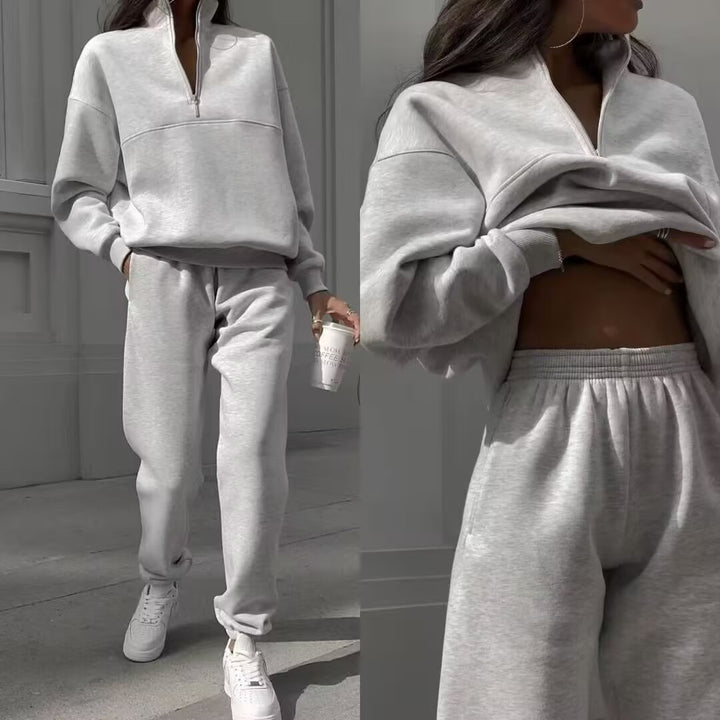 Gray tracksuit worn by a person, with close-up details on a neutral background.