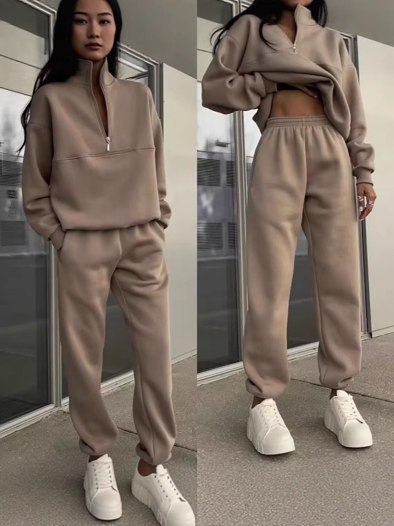 Person wearing a beige tracksuit with white sneakers in front of a mirror.