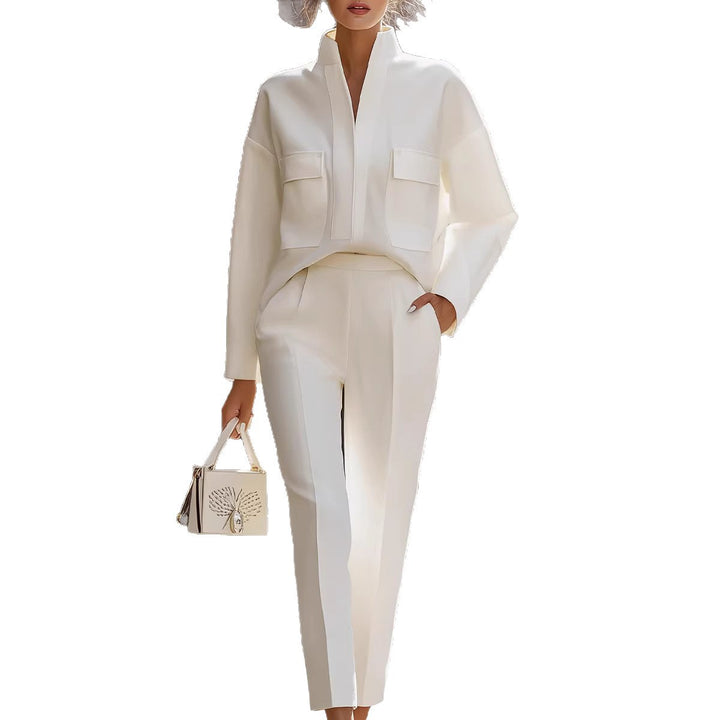 Person wearing a white outfit with a matching handbag on a white background