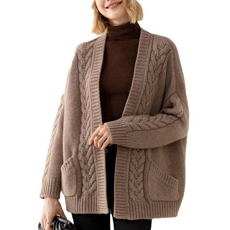 Woman wearing a brown cable knit cardigan on a white background