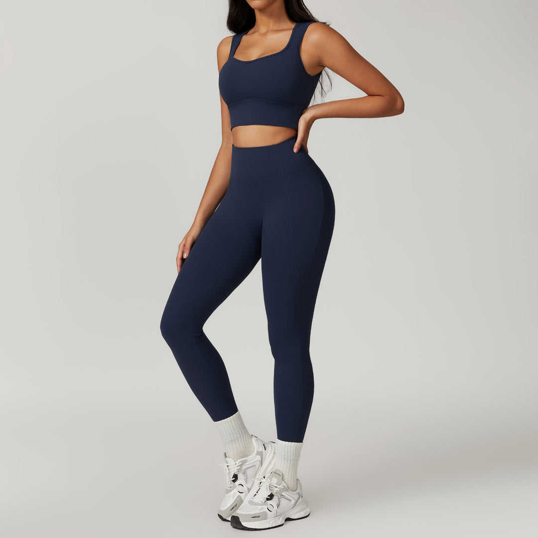 Person wearing a navy blue athletic outfit on a gray background