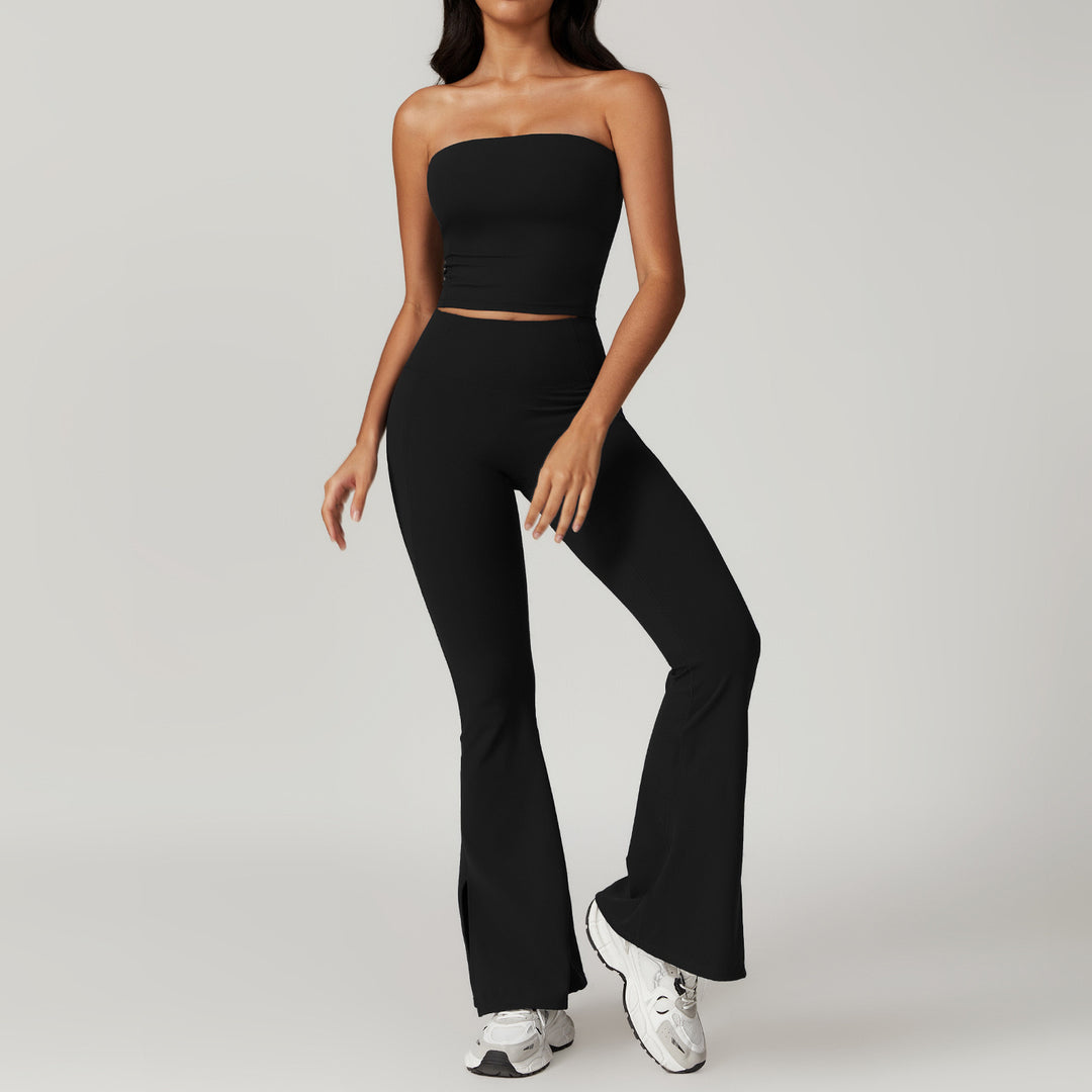 Person wearing a black strapless top and high-waisted pants with white sneakers on a light gray background
