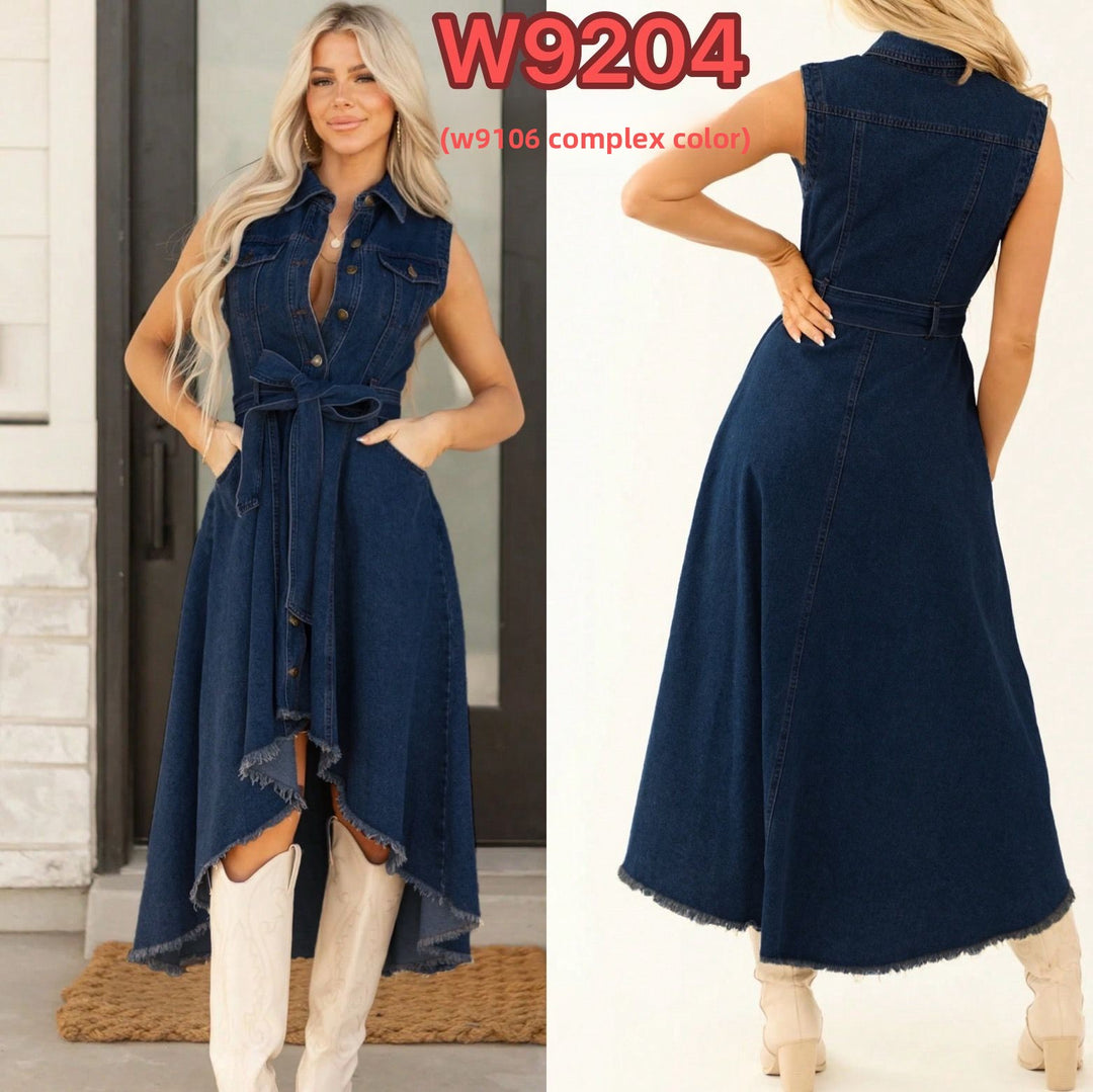 Woman wearing a blue denim dress with a belt, standing in front of a white door.