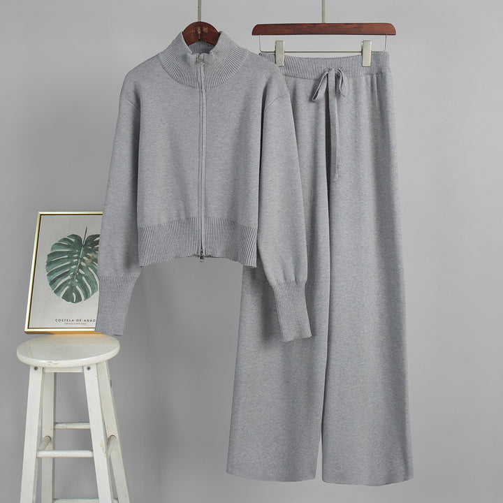Gray knit outfit with jacket and pants on hangers against a gray background